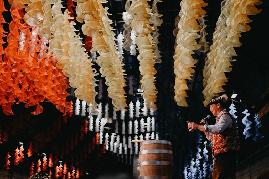 Jason Hurta on stage with a microphone beside a keg at a German heritage festival